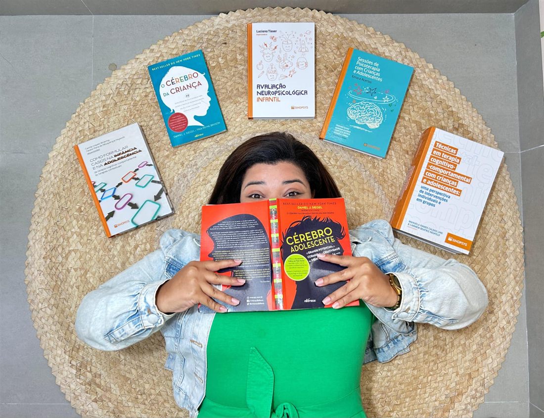 Jayane Coelho com livros de referência em Psicologia e Neuropsicologia