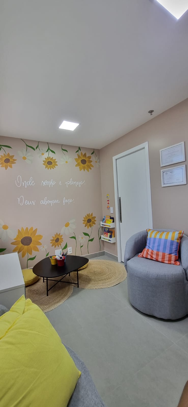 Sala de atendimento infantil com mural de girassóis