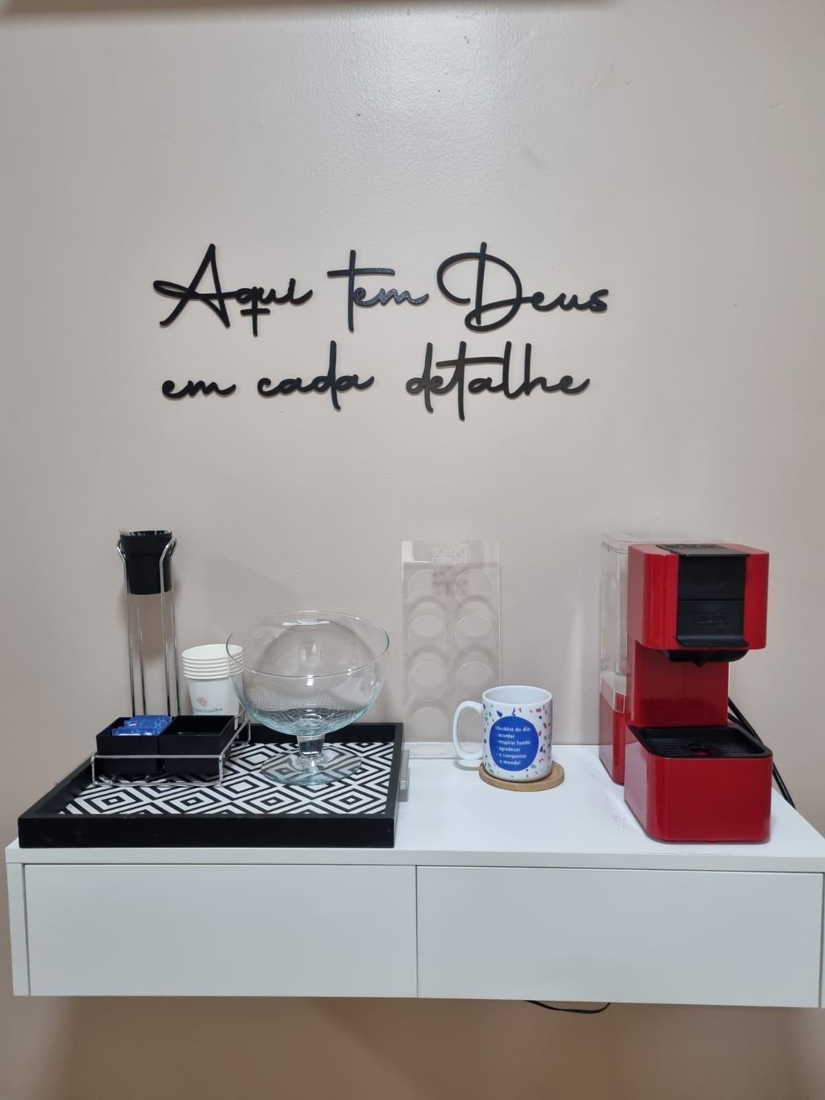 Cantinho de café da sala com a frase 'Aqui tem Deus em cada detalhe'